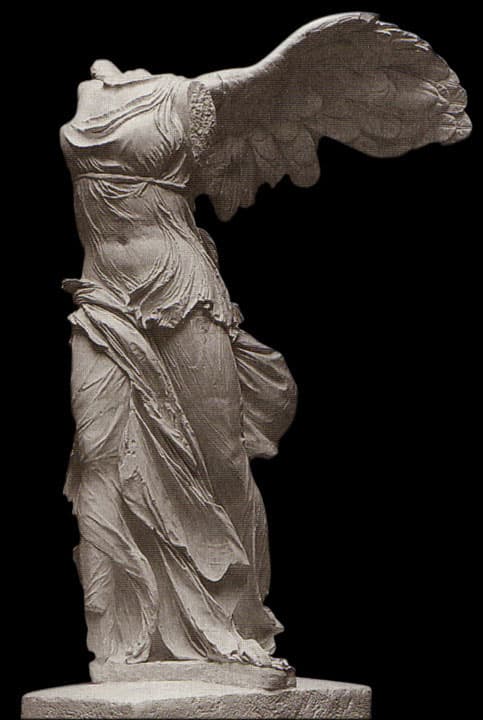 A photograph of the Winged Victory of Nike of Samothrace, a famous ancient Greek marble sculpture, shown from the side against a black background.