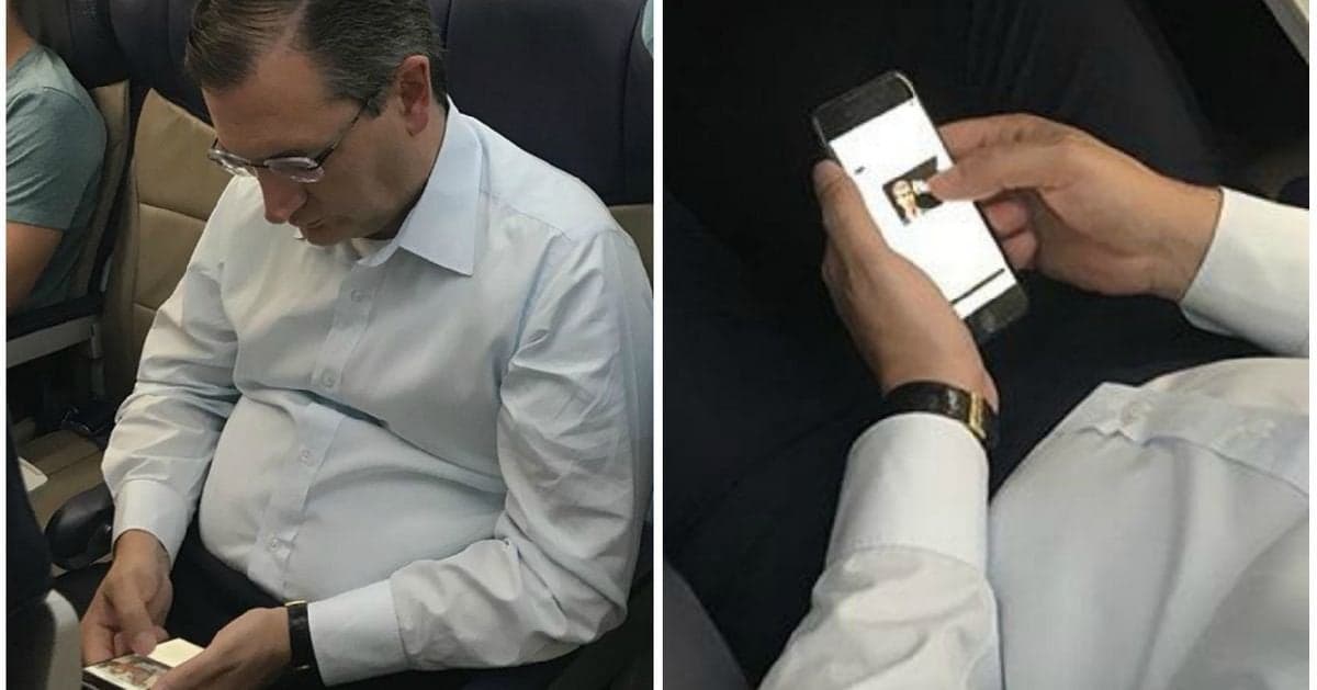 A split-screen image showing a man in a white dress shirt sitting in an airplane seat. The left panel shows him looking down at a smartphone, while the right panel provides a close-up of his hands holding the phone, which displays a photo of a woman.