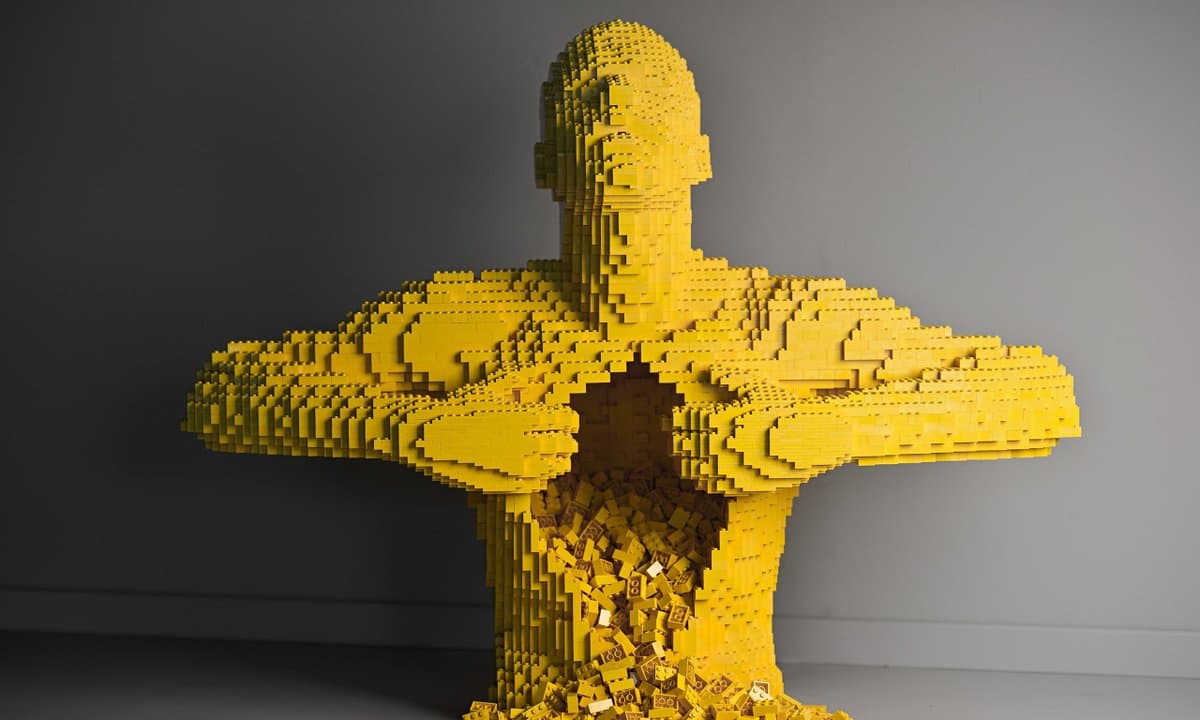 A digital rendering of a humanoid figure constructed from yellow Lego bricks, with a hollowed-out chest cavity revealing a pile of loose bricks inside.