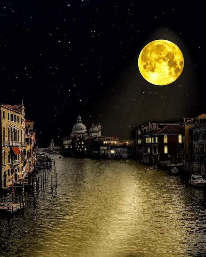 A digital illustration of a Venetian canal at night, featuring a large, glowing full moon in a starry sky. The moonlight reflects on the water, illuminating the historic buildings and a domed church in the distance.
