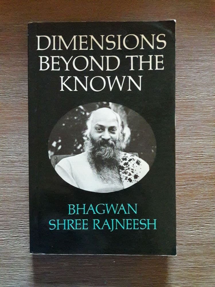 A photograph of a book titled "Dimensions Beyond the Known" by Bhagwan Shree Rajneesh, featuring a black-and-white portrait of a bearded man on the cover.