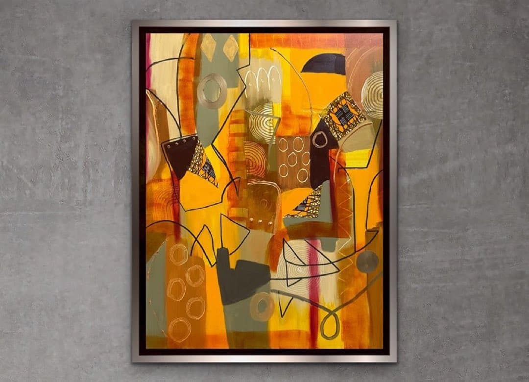 A framed abstract painting featuring a warm palette of yellows, oranges, and browns with geometric shapes and line work, displayed against a textured gray wall.