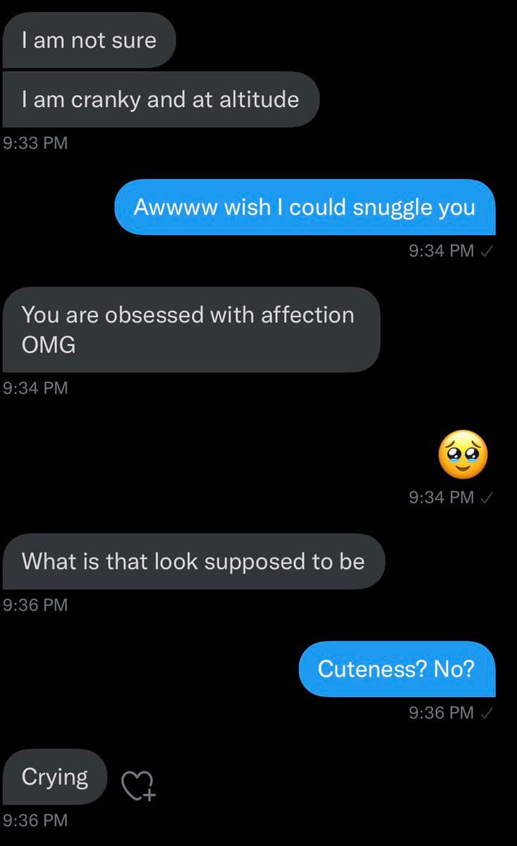 A screenshot of a text message conversation between two people on a dark-mode messaging app. The exchange shows one person expressing a desire to snuggle, while the other responds with frustration and confusion about the affectionate behavior.
