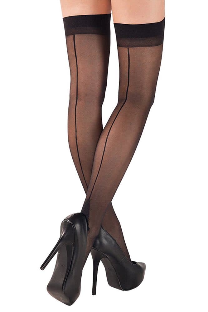 A product-style photograph showing a person's legs from the mid-thigh down, wearing sheer black thigh-high stockings with a back seam and black high-heeled platform shoes, posed with crossed ankles against a white background.