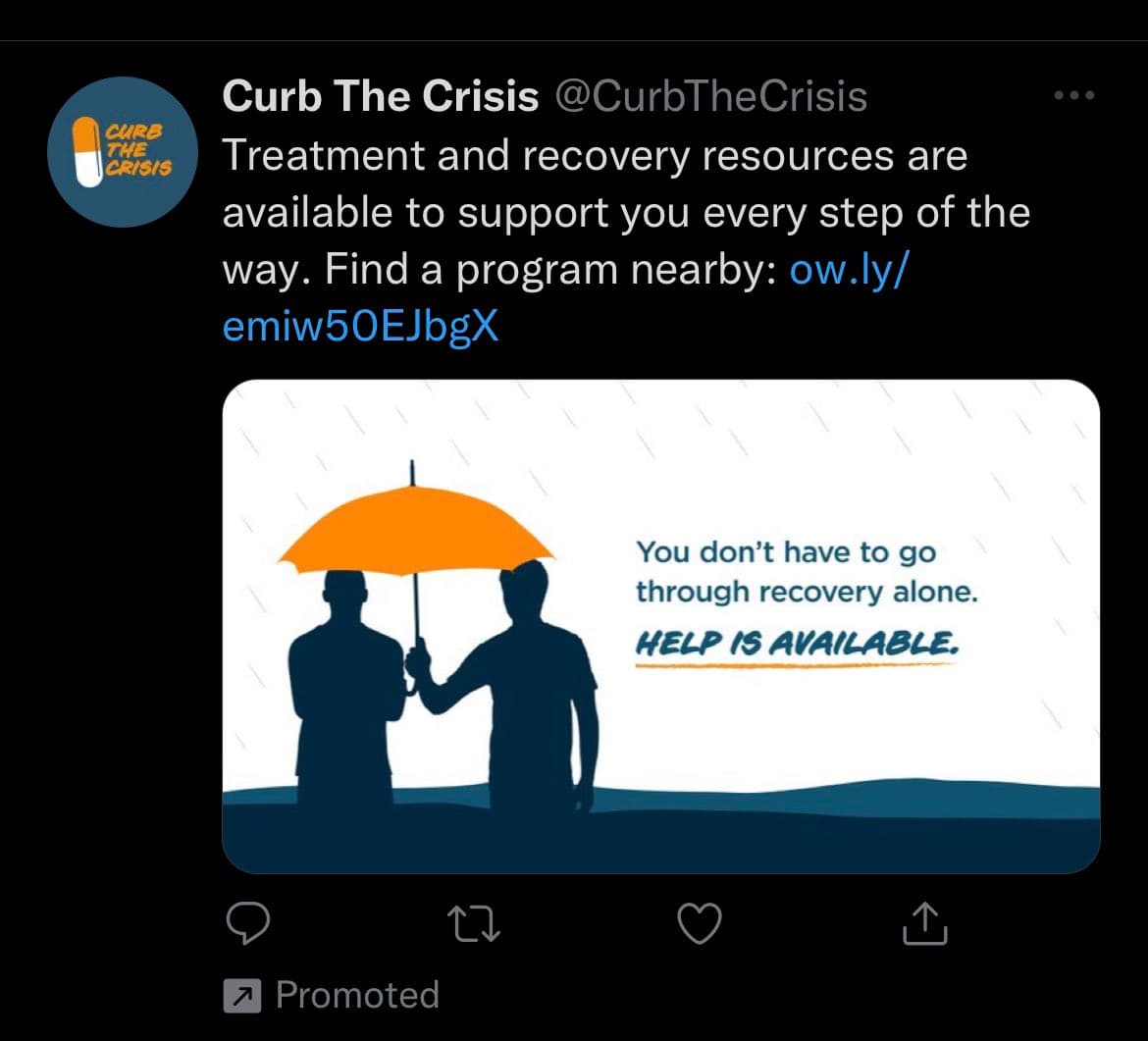 A screenshot of a promoted tweet from the account @CurbTheCrisis, which offers treatment and recovery resources. The attached image is a graphic showing two silhouetted figures sharing an orange umbrella in the rain, with the text 'You don't have to go through recovery alone. HELP IS AVAILABLE.'
