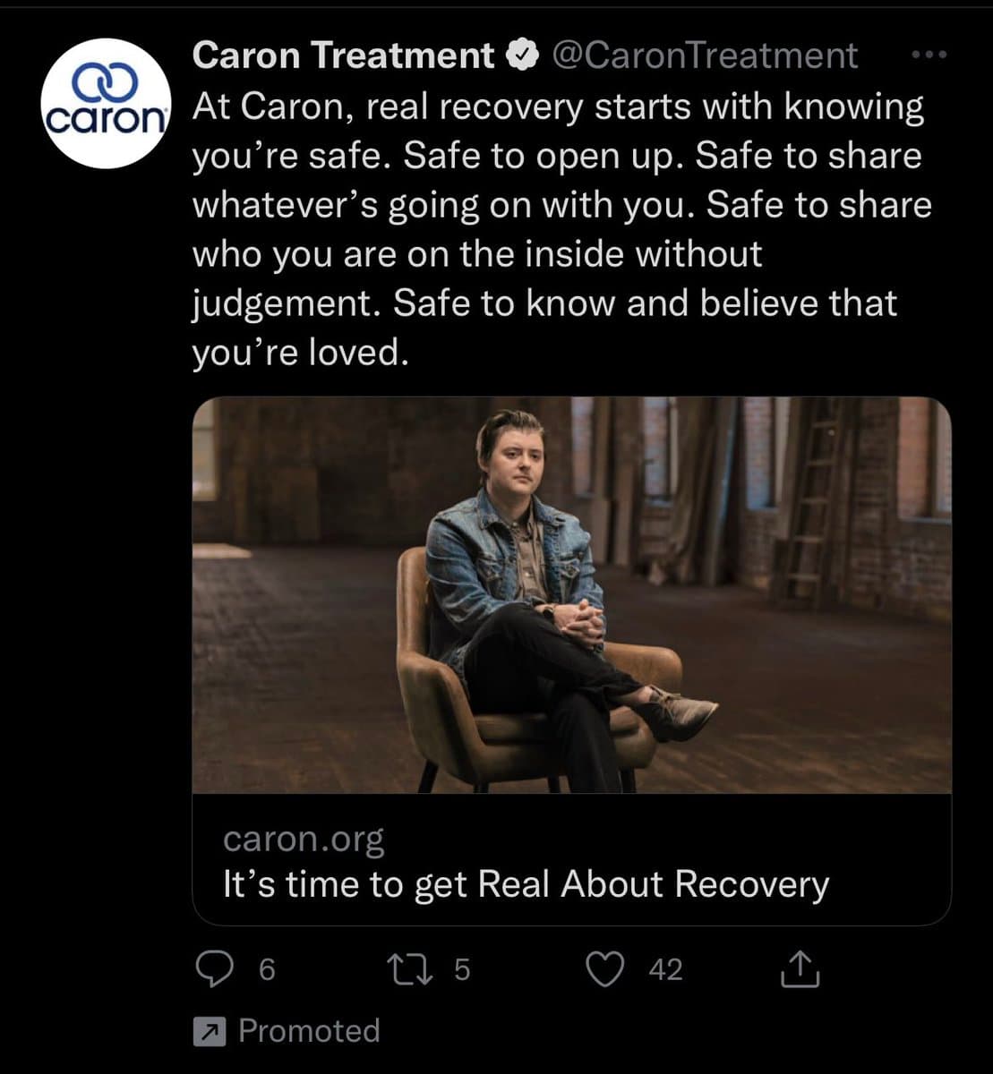 A screenshot of a promoted tweet from the verified account @CaronTreatment, featuring an advertisement for addiction recovery services. The ad includes a photo of a person sitting in a chair in a rustic room, with text emphasizing safety and non-judgment in recovery.