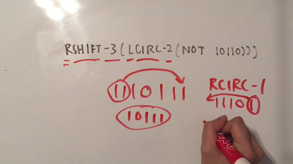 A whiteboard showing a step-by-step explanation of bitwise operations on binary numbers, written in black and red marker. A hand holding a red marker is visible in the lower right corner.