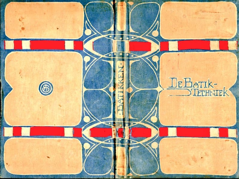 A flat-lay photograph of an open book with an Art Nouveau design featuring blue, red, and cream colors. The book is titled 'De Batik-Techniek' and displays a symmetrical pattern of organic shapes and geometric bands.