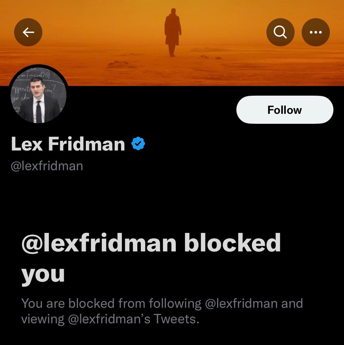 A screenshot of a Twitter profile page showing that the user has been blocked by the account owner. The profile header is a silhouette of a person walking on a beach at sunset, and the profile picture shows a man in a suit standing in front of a chalkboard.