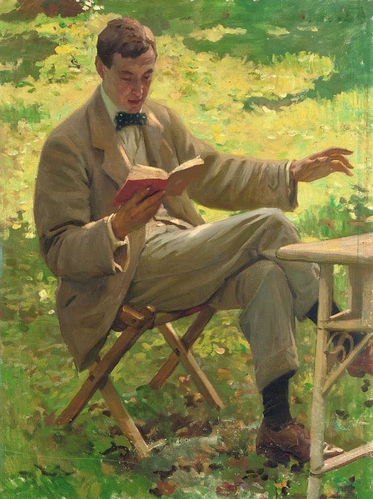 An oil painting depicts a man in a beige suit and bow tie sitting on a wooden folding chair outdoors, reading a small red book while gesturing with his other hand. The background consists of impressionistic green foliage and dappled sunlight.