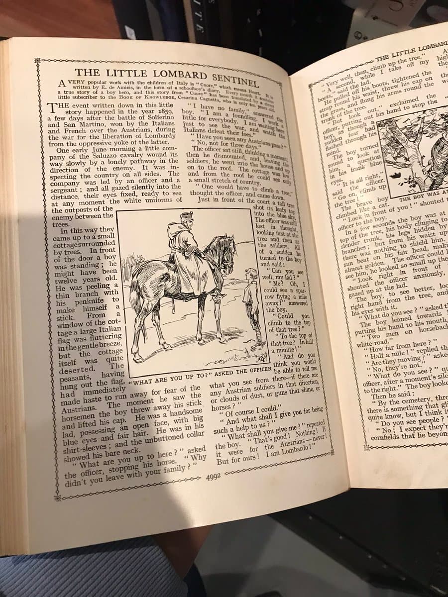 A photograph of an open vintage book displaying a two-page spread of a story titled 'The Little Lombard Sentinel.' The left page features a large illustration of a mounted officer speaking to a young boy, while the right page contains the continuation of the text and a smaller illustration of a boy climbing a tree.