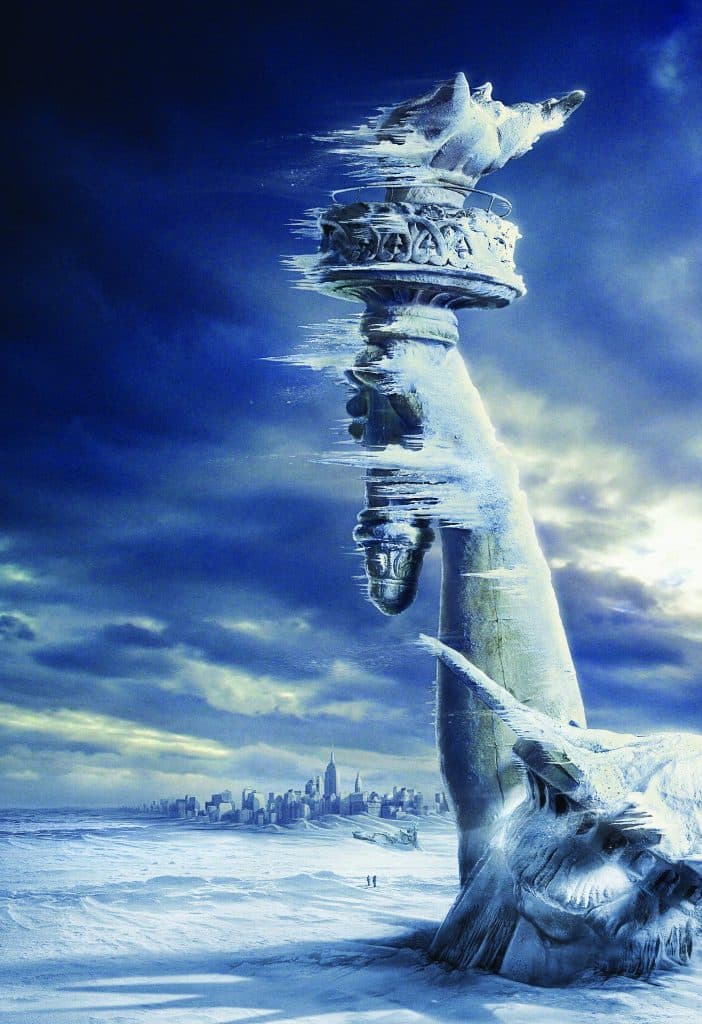 A surreal digital artwork depicting the Statue of Liberty lying face-down in a vast, snow-covered landscape with a city skyline in the distance. The statue's upper body and torch are shown melting or dissolving into the cloudy blue sky above.