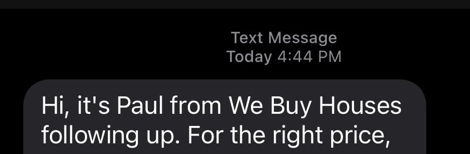 A screenshot of a text message notification on a dark background. The message is from a sender identified as Paul from We Buy Houses, following up on a potential house purchase.
