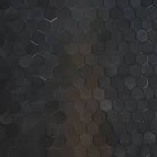 A close-up view of a dark, textured surface covered in a hexagonal pattern of heat-resistant tiles, with a vertical band of lighter, brownish discoloration running down the center. The image appears to be a photograph of the exterior of a spacecraft, likely a SpaceX Starship, showing signs of thermal stress.