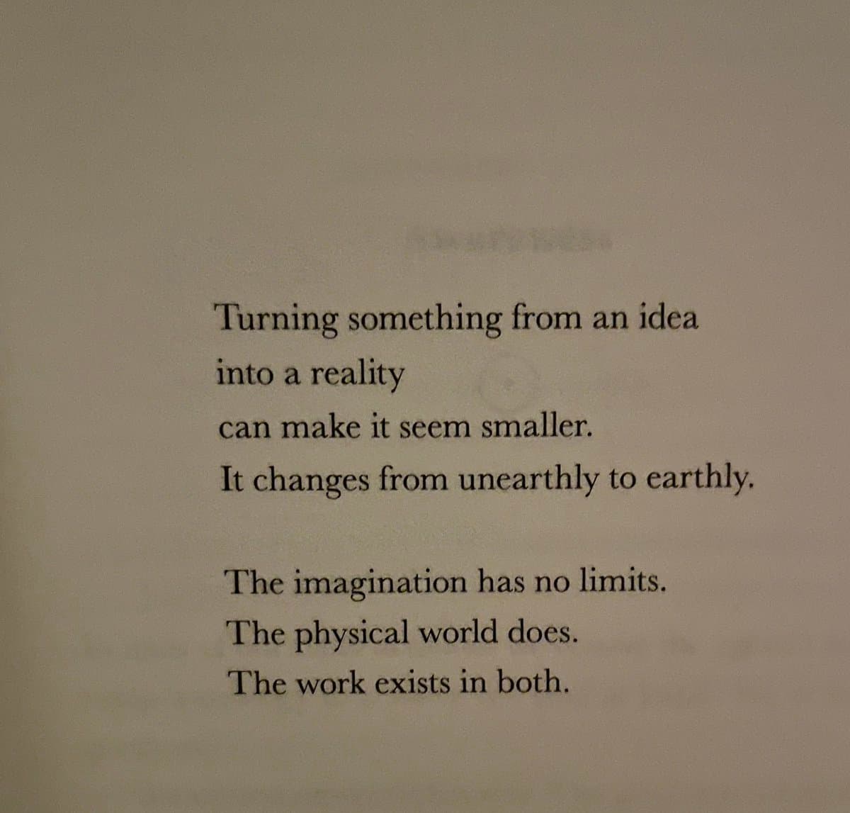 A photograph of a printed page containing a short, reflective poem or quote about the nature of creativity and reality.