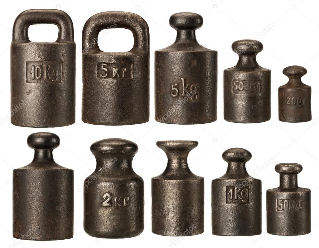 A collection of ten vintage, dark metal calibration weights arranged in two rows against a white background. The weights vary in size and shape, with some featuring handles and others having knob-like tops, and are marked with their respective mass values.