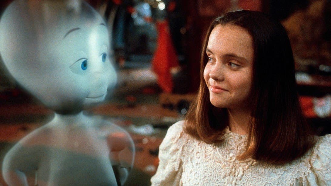 A still from a film showing a young woman with shoulder-length brown hair looking at a translucent, blue-skinned animated character.