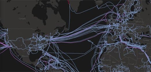 A dark-themed world map showing a network of colored lines (blue, purple, and red) connecting various locations, representing data or communication flows between continents. The map highlights dense clusters of connections in North America and Europe, with lines spanning across the Atlantic and Pacific Oceans. Country labels such as Canada, Mexico, Spain, France, Germany, and Russia are visible on the map.