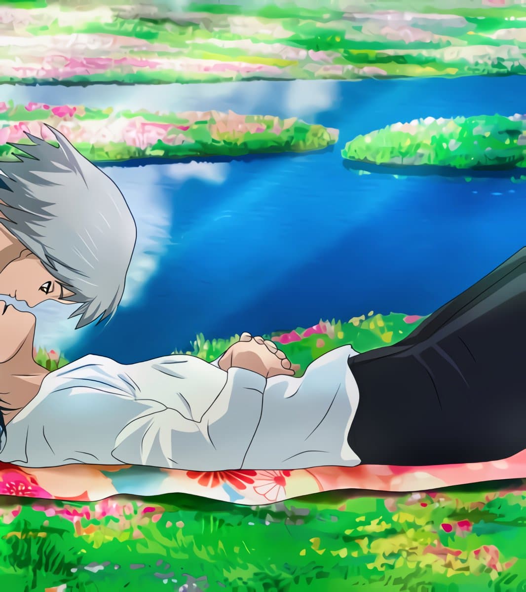 A still from the animated film Howl's Moving Castle showing a character with white hair lying on a floral blanket beside a blue pond. The character is wearing a white shirt and black pants, resting with their hands clasped.