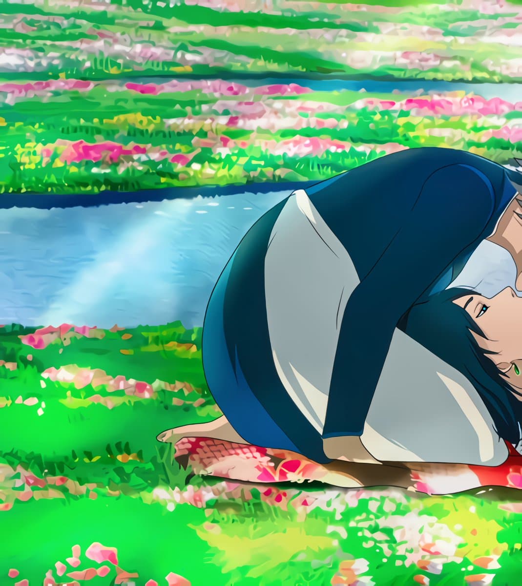 A still from the animated film Howl's Moving Castle (2004) showing a character with dark hair and a blue top kneeling on a red and white patterned cloth in a vibrant field of green grass and pink flowers. The character is bent forward with their head resting on their arms, looking toward the right side of the frame.