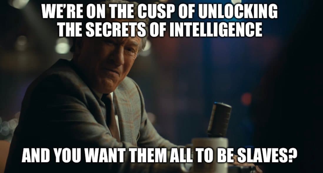 A meme featuring a still of a man in a suit sitting at a table with a microphone, overlaid with white text. The image is used to make a point about AI alignment.