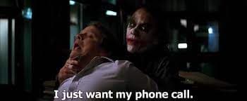 A still from the movie The Dark Knight showing the Joker standing behind a man in a white shirt, with the Joker's hand on the man's neck. The image has a dark, cinematic quality with a caption at the bottom. The post text references a '201 status code', which is a play on the caption 'I just want my phone call.'