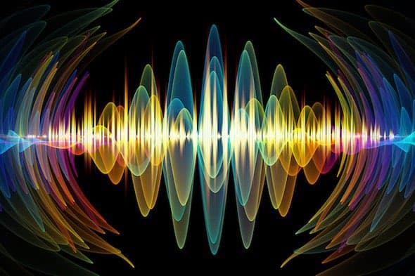 A colorful, abstract digital illustration of a sound wave on a black background, featuring symmetrical, rainbow-hued waveforms that expand outward from a central point. The image has a vibrant, neon aesthetic with overlapping translucent lines in shades of blue, green, yellow, orange, and red. There is no legible text present in the image.