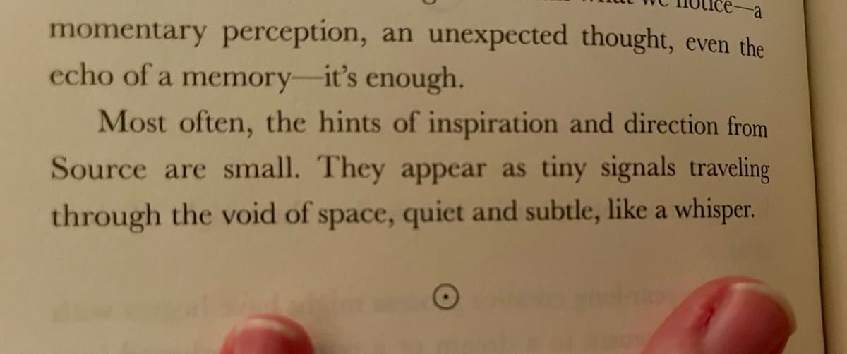 A close-up photograph of an open book page, held by a person's fingers, displaying printed text about inspiration and subtle signals. The text is in a serif font on off-white paper.