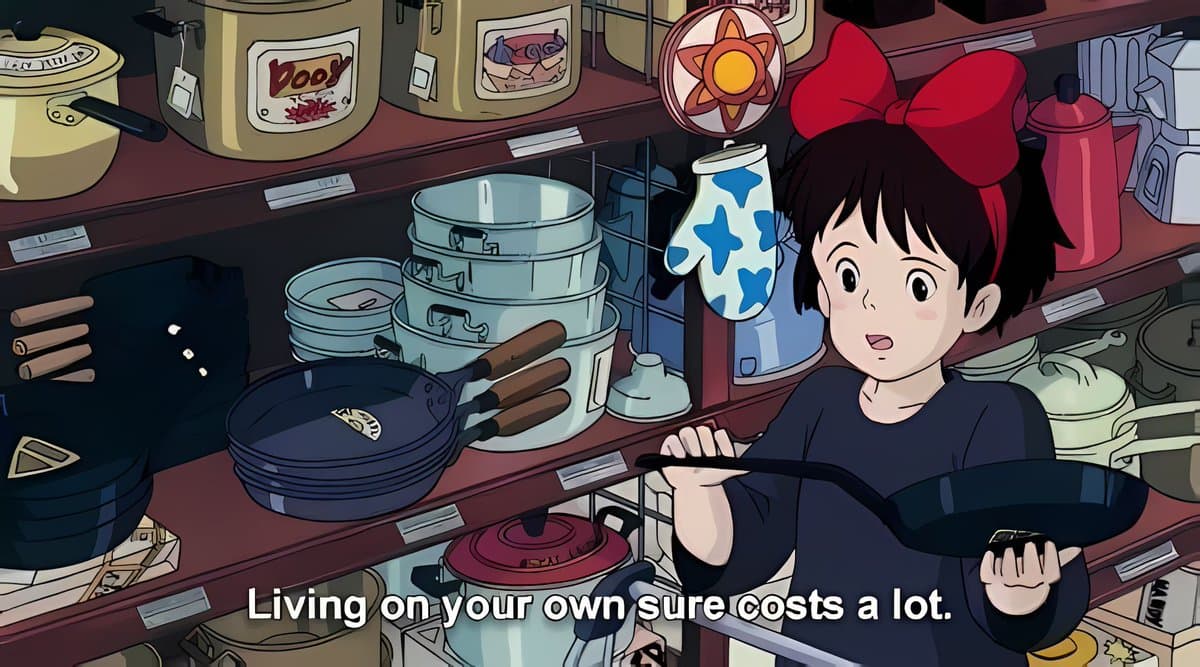 A still from the animated film Kiki's Delivery Service, showing a young girl with a large red bow holding a frying pan in a kitchen filled with pots and pans. The image includes English subtitles at the bottom.