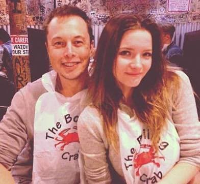 A photo of a man and a woman posing together, both wearing white t-shirts with a red crab logo and the text 'The Bill Crab'.