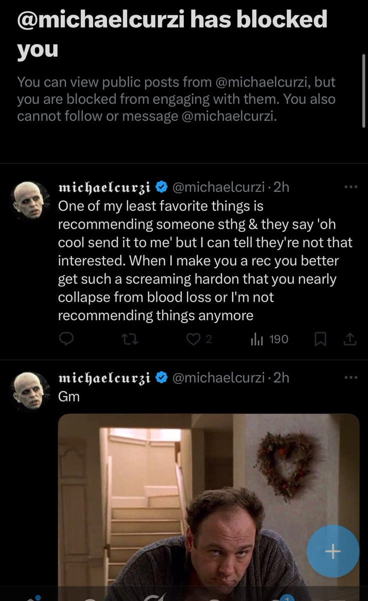 A screenshot of a Twitter profile page showing a 'blocked' notification at the top, followed by two posts from the user @michaelcurzi. The first post is a long text rant, and the second post contains a short text and an embedded image of a man looking down.