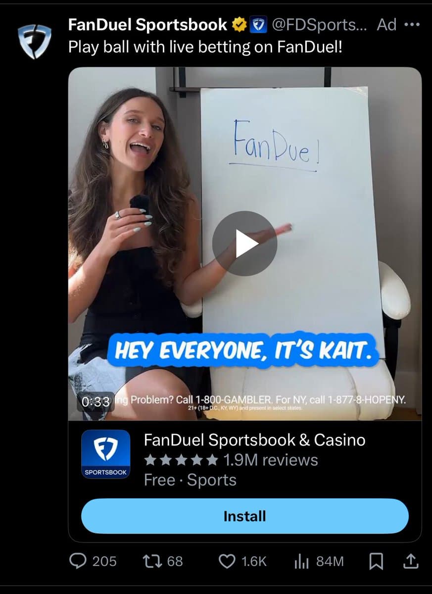 A screenshot of a Twitter post featuring an advertisement for FanDuel Sportsbook. The ad shows a video thumbnail of a woman next to a whiteboard with 'FanDuel!' written on it, along with app store details and engagement metrics.