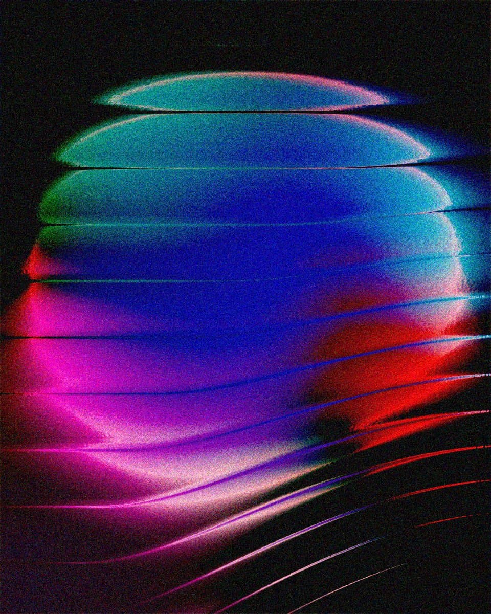 An abstract digital artwork featuring a glowing, segmented sphere composed of horizontal bands in vibrant neon colors, including blue, green, pink, and red, set against a black background. The image has a grainy, retro-futuristic aesthetic with light streaks extending from the lower right.