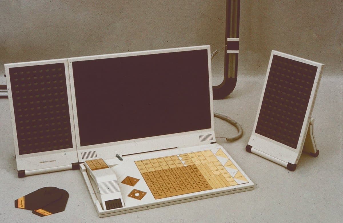 A photograph of the SPHINX, a Soviet computer concept from 1987, featuring a central monitor, a keyboard with a Cyrillic layout, and two side panels with grid patterns.