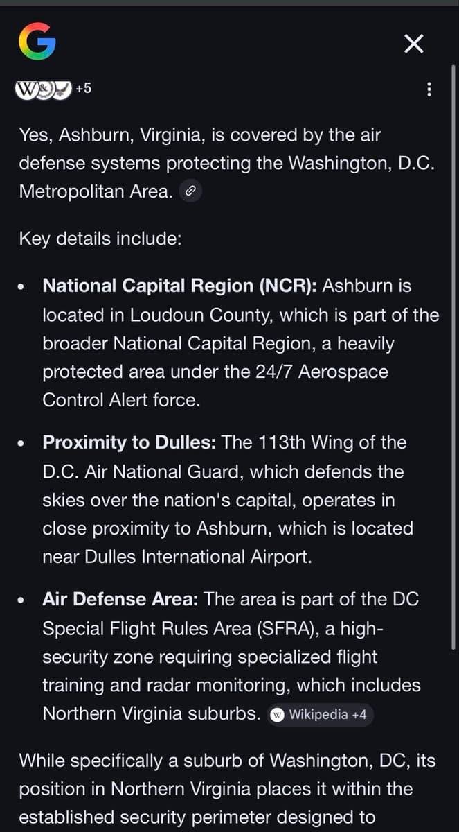 A screenshot of a Google search result page in dark mode, displaying an AI-generated summary about Ashburn, Virginia's air defense coverage. The text explains that Ashburn is part of the National Capital Region (NCR), is near Dulles International Airport, and falls within the DC Special Flight Rules Area (SFRA).